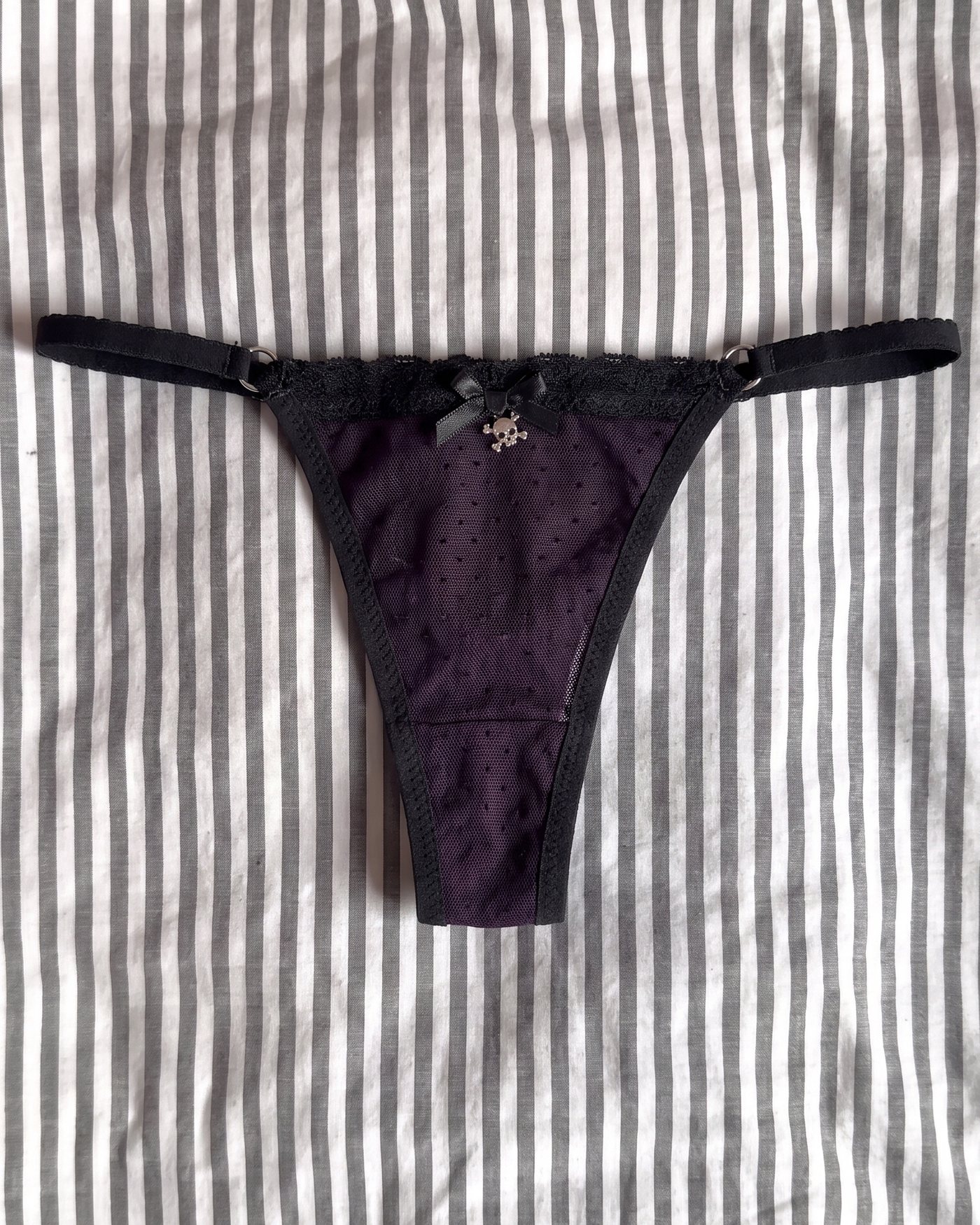 The thong with the satin bow and silver skull charm