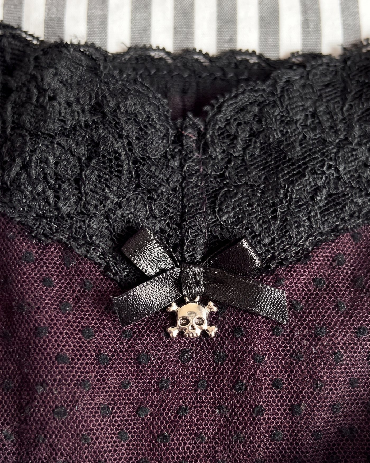 Close up of the satin bow and the silver skull charm